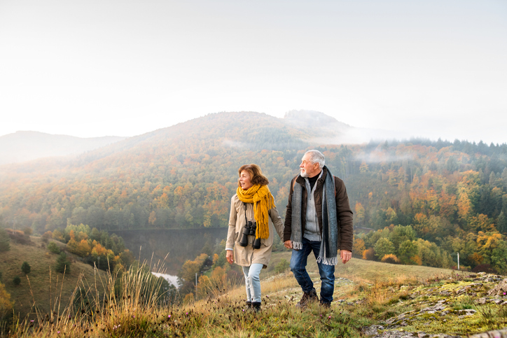 senior couple out walking wearing warm clothing awaiting winter