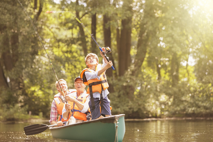 Young boy and their family fishing from a small pond on a lake