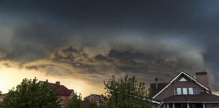 house in summer thunderstorm. dark clouds above.