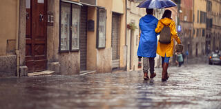 Back view of couple on rainy day while walking on the street