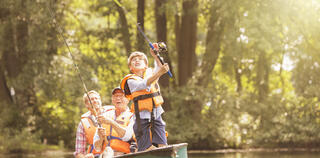 Young boy and their family fishing from a small pond on a lake