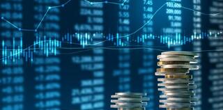 pile of coins and investing graphs