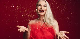 Excited senior woman throwing glitters