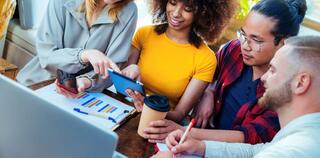 group of co-workers working with tablet and laptop