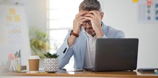 A business man in the laptop, stressful and with headaches