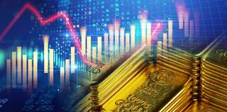 stack of shiny gold bars on down trend financial gold price graph