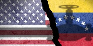 Flag of USA and Venezuela painted on a concrete wall with crude oil pipe shadow