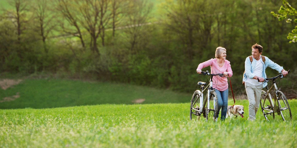 Couple with bicycles and a beagle.