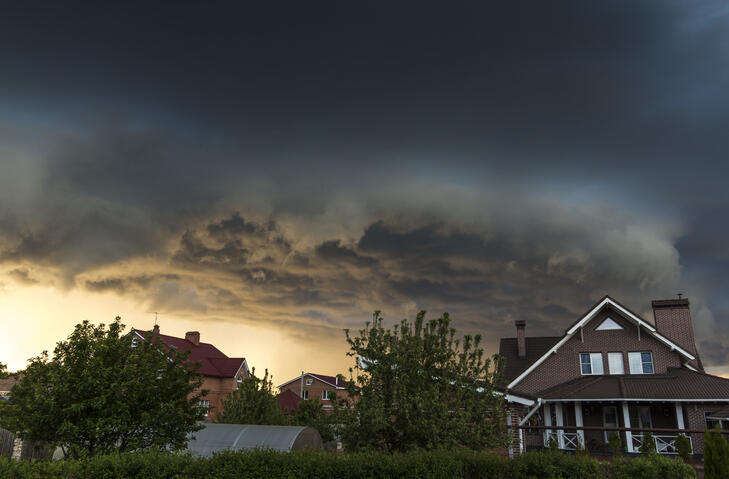house in summer thunderstorm. dark clouds above.